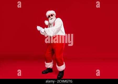 Vista a tutta lunghezza del corpo della sua bella allegra Divertente positivo bearded Babbo Natale hipster ballare divertendosi indossando festal occhiali da sole Foto Stock