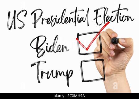 Vota per il nuovo presidente, elezioni USA 2020 con casella di controllo. Doodle su una lavagna bianca, scritta con un pennarello nero in una mano. Tracciare il testo dello schizzo su un bianco Foto Stock