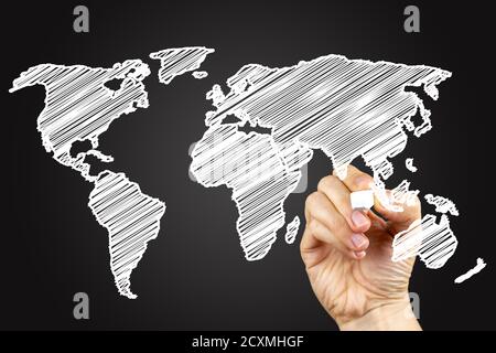 Mappa del mondo. Doodle disegnando su una lavagna, scritta con gesso bianco in una mano. Foto Stock