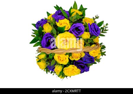 Cesto con fiori gialli e blu su fondo bianco isolato. Vista dall'alto di un bouquet di rose gialle e violette. Bellissimi fiori in un basco di vimini Foto Stock
