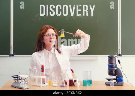 Donna scienziata sorpresa con un pallone in mano ha fatto una scoperta scientifica. Condurre ricerche scientifiche nel laboratorio degli studenti Foto Stock