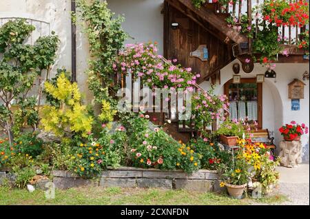 FELTRE, Italia - 13 agosto 2020: Primo piano della facciata di una tradizionale casa di campagna decorata con piante e fiori Foto Stock