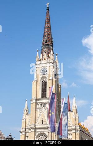 Il nome di Maria la Chiesa, noto anche come Novi Sad cattedrale cattolica in un pomeriggio soleggiato con le bandiere della Voivodina provincia, Serbia e Novi Sad. Th Foto Stock