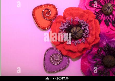 San Valentino, prodotti fatti a mano dal feltro, due cuori e molti colori di feltro su uno sfondo rosa Foto Stock