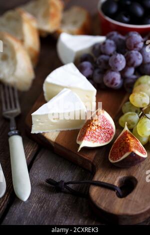 prima colazione all'italiana: uva, brie, salame, fichi e olive Foto Stock