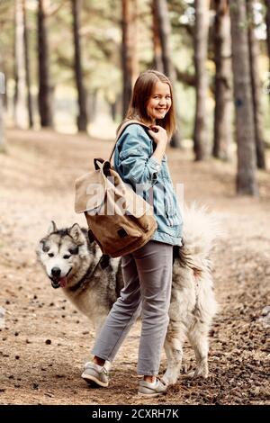 Giovane ragazza con il suo cane, Alaskan Malamute, all'aperto in autunno. Animali domestici Foto Stock