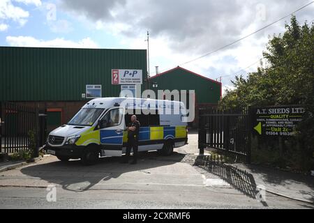 Un veicolo di polizia che blocca un ingresso alla zona industriale di Albion Works a Brierley Hill, West Midlands, nella zona in cui due uomini sono stati trovati uccisi in un'auto il mercoledì pomeriggio. Foto Stock