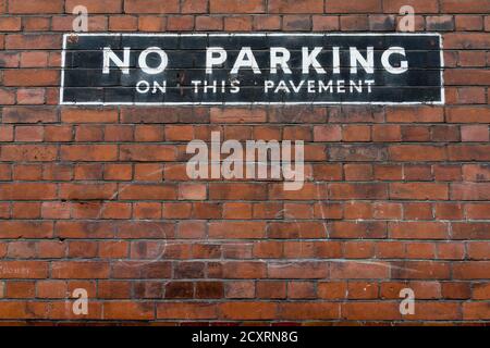 Un segno dipinto su un muro di mattoni dice No Parking su questo pavimento. L’area di Soho del West End di Londra in un giorno freddo e umido di gennaio. 31 gennaio 2016. PH Foto Stock