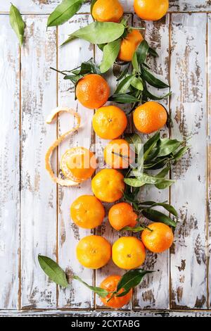 Mature clementine organici o i tangerini con foglie su bianco tavolato in legno tabella come sfondo. Vista superiore, spazio. Mangiare sano Foto Stock