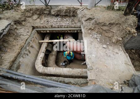 Bucarest, Romania - 1 ottobre 2020: Buco nel terreno fatto dai lavoratori del municipio per cambiare i tubi dell'acqua calda dall'energia termica di Bucarest d Foto Stock