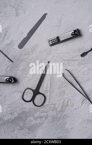 Set di manicure, attrezzi e accessori per pedicure, fondo in pietra e calcestruzzo, vista dall'alto Foto Stock