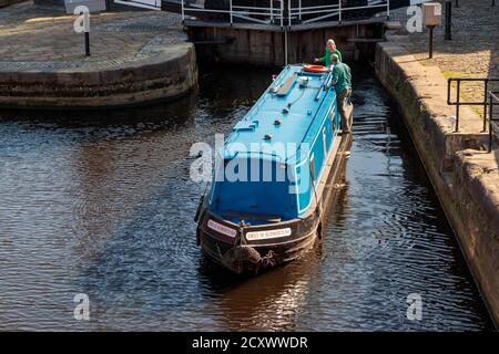 Vista di persone non identificate e una barca canale che naviga lungo il fiume Aire Island Lock, Leeds Foto Stock