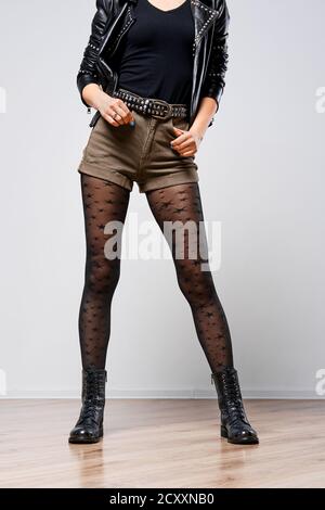 Gambe sottili femminili in pantyhose nero con stelle Foto Stock