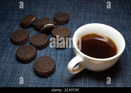 Tazza bianca di caffè scuro e biscotti Foto Stock