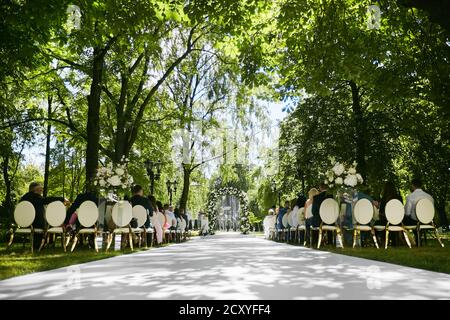 Registrazione matrimonio bella in natura. Sedie bianche e dorate per la registrazione delle visite, fiori bianchi per la registrazione delle uscite. Dettagli del matrimonio Foto Stock
