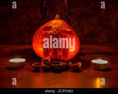 Tema di Halloween - conchiglie di zucca e noce al buio, illuminate da candele Foto Stock