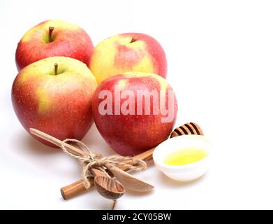 Composizione di mele e rustico di posate. Set di frutta, cucchiai di legno e miele in bianco piattino. Eco Design e raccolti autunnali concetto. Mele e cucchiai isolati su sfondo bianco Foto Stock