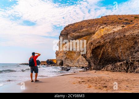 Uomo caucasico escursionista sulla spiaggia Cala de la Media Luna in Almeria, situato in Andalusia, Spagna Foto Stock