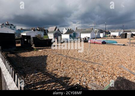 Un gruppo di capanne per pescatori sulla spiaggia di Walmer, illuminate contro un cielo che si abbassa Foto Stock