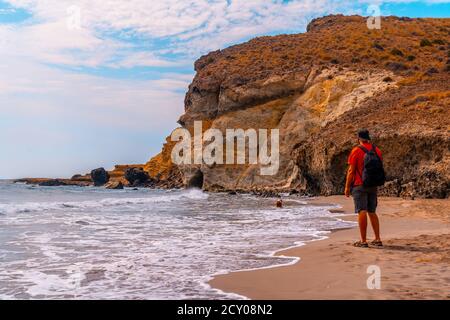 Uomo caucasico escursionista sulla spiaggia Cala de la Media Luna in Almeria, situato in Andalusia, Spagna Foto Stock