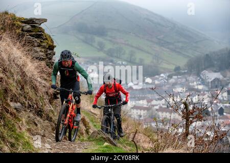 Due uomini cavalcano mountain bike su un sentiero a Glyncorrwg, nella valle di Afan, nel Galles meridionale. Foto Stock