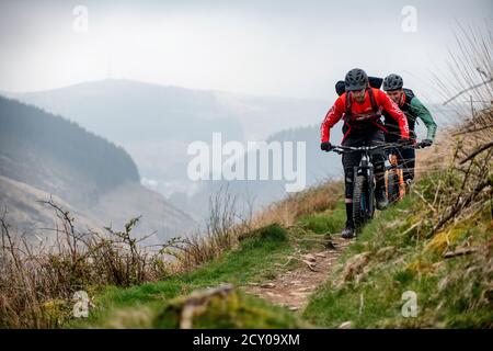 Due uomini cavalcano mountain bike su un sentiero a Glyncorrwg, nella valle di Afan, nel Galles meridionale. Foto Stock