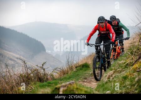 Due uomini cavalcano mountain bike su un sentiero a Glyncorrwg, nella valle di Afan, nel Galles meridionale. Foto Stock
