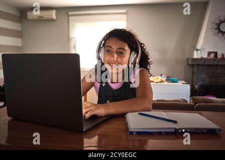 una ragazza si è concentrata sul fare il suo lavoro a casa. Concetto scolastico Foto Stock