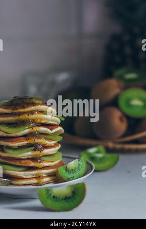 Piatto di frittelle gocciolando con kiwi marmellata con pezzi kiwi. Shrovetide Maslenitsa Butter Week pasto festival. Shrove Martedì. Pancake giorno Foto Stock