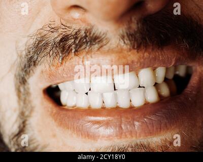 Bocca maschio sorridente con denti bianchi. Primo piano Foto Stock