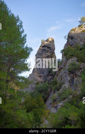 Vista di una grande roccia attaccata alle scogliere di montagna dei Port de Beseit, nella zona Parrizal, Beseit, Matarranya, Aragón, Spagna Foto Stock