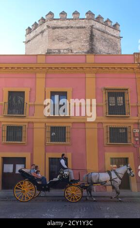 Siviglia, Spagna - 27 settembre 2019: Carrozza a cavallo che attraversa la Torre de la Plata. Siviglia, Spagna. Vista da via Temprado Foto Stock