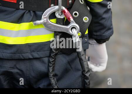 Dettagli con il moschettone e l'imbragatura di un pompiere. Foto Stock