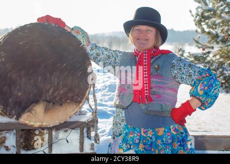 Sciamano femminile sulla natura invernale con un grande tamburo Foto Stock