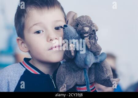 Il volto del ragazzo con un mouse giocattolo, primo piano Foto Stock