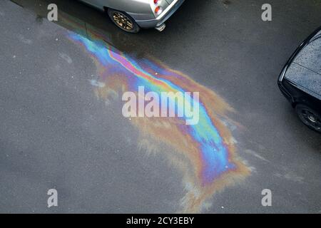 Modelli multicolore sulla strada dall'olio lubrificante dell'auto dopo la pioggia Foto Stock