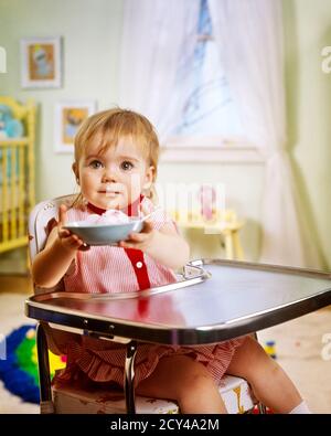 1970 1980 BAMBINA CHE TIENE IN SU PIATTO DI CIBO SEDUTO DENTRO SEGGIOLONE IN ACCIAIO INOX NELLA CAMERA DA LETTO GUARDANDO WINSOME - KF8691 PHT001 HARS FEMMINE VINCENTI SALUBRITÀ HOME VITA COPIA SPAZIO PERSONE FELICITÀ SEGGIOLONE NUTRIZIONE UP CONNESSIONE INOX CONSUMARE NUTRIMENTO GHIACCIO CREMA PIACEVOLE PIACEVOLE PIACEVOLE PIACEVOLE AFFASCINANTE CRESCITA GIOVANILE AMABILE PIACEVOLE ADORABILE APPELLO BAMBINA CAUCASICA ETNIA VECCHIO STILE WINSOME Foto Stock