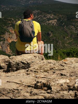 Escursionista visto dalla parte posteriore guardando il paesaggio di montagna Foto Stock