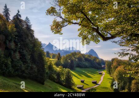 DE - BAVIERA: La strada per Wamberg vicino Garmisch-Partenkirchen con Alpspitze, Zugspitze e Waxenstein montagne sullo sfondo. (Immagine HDR) Foto Stock