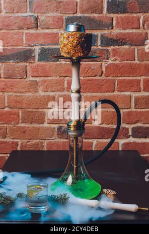 Shisha con coppa di frutta con fumo colorato in Hookah Bar Closeup. Foto Stock