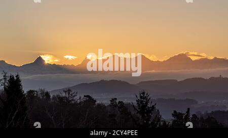 Alba dietro le Alpi bernesi in Svizzera Foto Stock