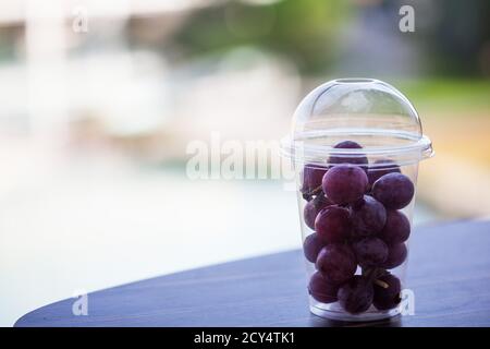 Un ramo di uva viola in plastica trasparente Foto Stock