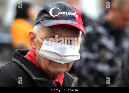 Un uomo anziano che indossa una maschera visto nel centro di Kiev. Foto Stock