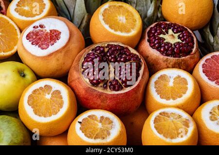 Melagrane e arance affettato aperto per la visualizzazione in vendita al mercato Foto Stock