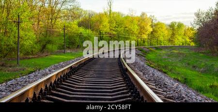 Binari ferroviari, paesaggio primaverile vicino alla strada dove passa il treno. Foto Stock