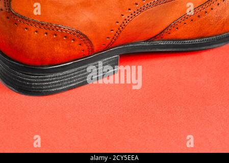 Scarpe uomo primo piano - su uno sfondo rosso con una copia dello spazio. Moda uomo. Vendita e consegna di scarpe dal negozio Foto Stock