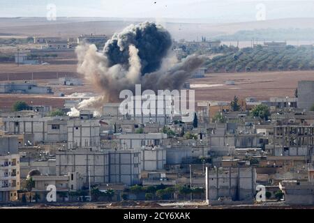 Smoke rises from the Syrian town of Kobani, seen from near the Mursitpinar border crossing on the Turkish-Syrian border in the southeastern town of Suruc in Sanliurfa province October 15, 2014. American-led forces conducted 21 airstrikes near Kobani, Syria,  in the last two days to slow the advance of Islamic State militants, the U.S. military said on Tuesday, warning the situation on the ground is fluid as militants try to gain territory.   REUTERS/Kai Pfaffenbach (TURKEY  - Tags: MILITARY CONFLICT POLITICS)