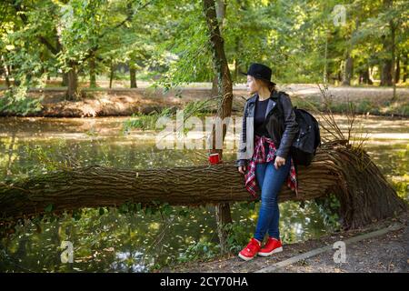 ragazza con una tazza rossa nel parco Foto Stock