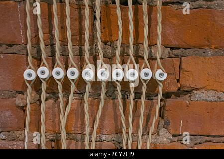 imitazione di vecchio design dei fusibili elettrici con fili elettrici su uno sfondo di mattoni rossi Foto Stock