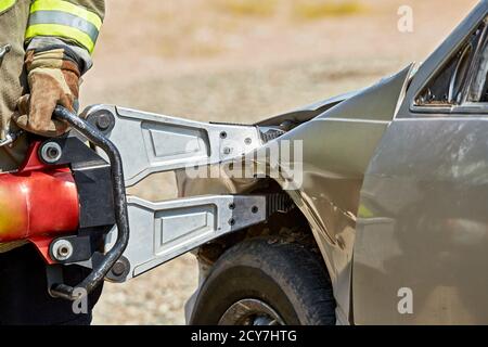 Corso di formazione paramedica studenti che imparano le tecniche di salvataggio utilizzando le JAWS Di vita su un'automobile distrutta Foto Stock